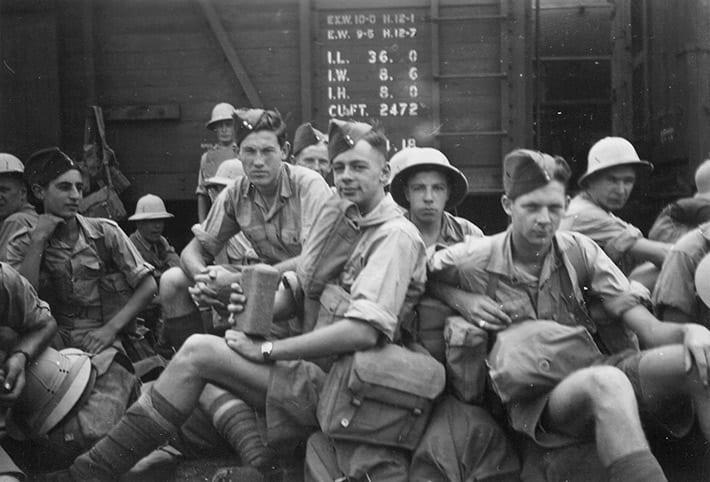 Photograph of Canadian soldiers, at railway station, Kingston, ON, ca. 1943. Rino Albanese is among the young men. At the age of 18, Rino Albanese and his twin Philip enlisted in active service with the Canadian military. They were trained at Petawawa, where most of the about 600 Italian Canadian internees were housed. At the same time, the twin's father, Giovanni was designated as an enemy alien. The brothers were sent overseas where they served with the Canadian forces in England, Holland, and Germany.